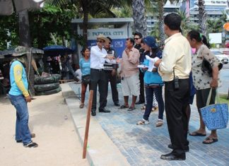 Pattaya Permanent Secretary Pakorn Sukhonthachat instructs city workers on where to drive their stakes as Pattaya and military officials begin outlining new zones for beach chairs and umbrellas on Pattaya Beach. The new regulations call for 10 meters of empty sand every 100 meters. Inside each zone, vendor concessions are to be separated by one meter.