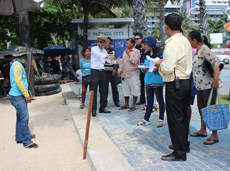Pattaya Permanent Secretary Pakorn Sukhonthachat instructs city workers on where to drive their stakes as Pattaya and military officials begin outlining new zones for beach chairs and umbrellas on Pattaya Beach. The new regulations call for 10 meters of empty sand every 100 meters. Inside each zone, vendor concessions are to be separated by one meter. 