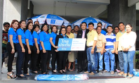 Samran Topao, sales manager for Thai Life Insurance Company, and his management team presents 3,000 umbrellas worth 3 million baht to Deputy Mayor Ronakit Ekasingh to distribute to Jomtien Beach vendors.