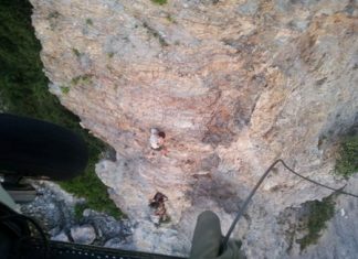A member of the Navy’s SEAL team is lowered down to pluck the stranded Greek from the side of the cliff.