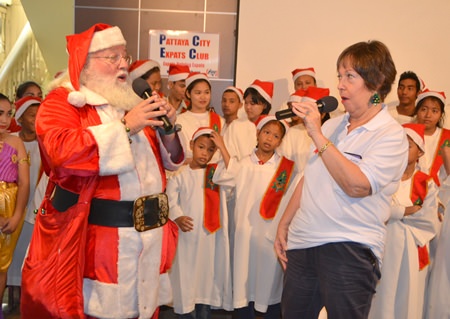Santa and Club member Judith Edmonds join together to sing Away in the Manger, inviting the audience to join in. Santa explained that there is both an English version and an American version; same words, different tune.