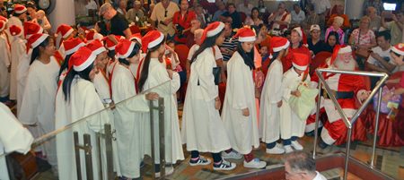 The children line up to receive a bag of goodies each from Santa.