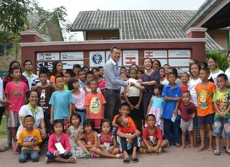CPDC receives 50,000 baht Christmas present Rudolf Hofer presents the money to Radchada Chomjinda, surrounded by the children.