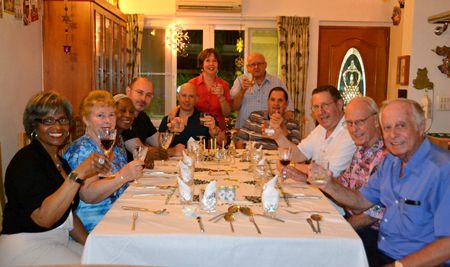 PCEC Treasurer Judith Edmonds and Les Edmonds (standing) welcome guests to their home to celebrate Hanukkah together.