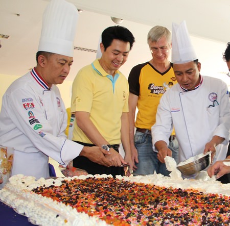 Poramet receives a helping hand in cake decorating.