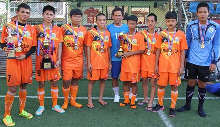 Shai Davis (centre) poses with the Banglamung Boys Home – the tournament winning team.