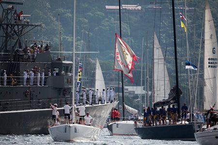 The fleet performs a ceremonial sail past a Royal Thai Navy warship to mark the birthday of His Majesty the King of Thailand on December 5. (Photo by Max Ranchi)