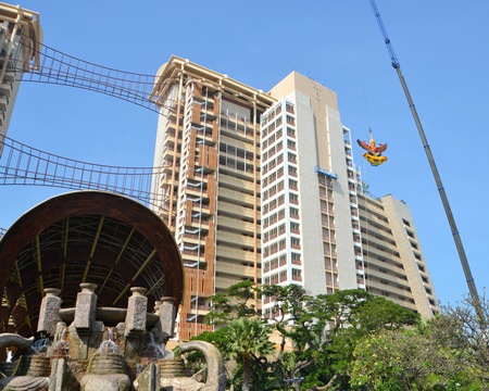 A crane reaches high into the sky to install the Royal Garuda atop the Centara Grand Mirage.