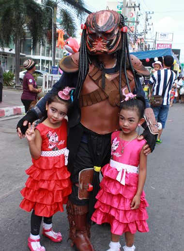 Children pose with a character from the movie “Predator”.
