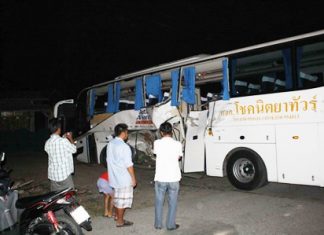 Onlookers stare at the damaged bus after an accident that killed one man and seriously wounded five others in Pong Sub-district.