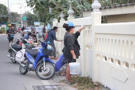 Volunteers grab paint and brushes to refurbish the outside walls at Suttawas Temple.