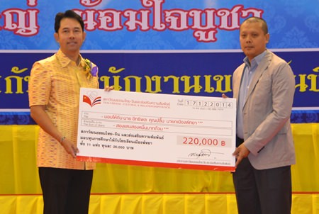 Bandit Siritanyong (right), vice chairman of the Thai-Chinese Culture and Economic Council, presents 11 scholarships worth 20,000 baht each, to Mayor Itthiphol Kunplome to give to students from each of the 11 public schools in Pattaya.