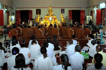 Monks and lay people say their prayers at the Chong Lom Naklua Temple.