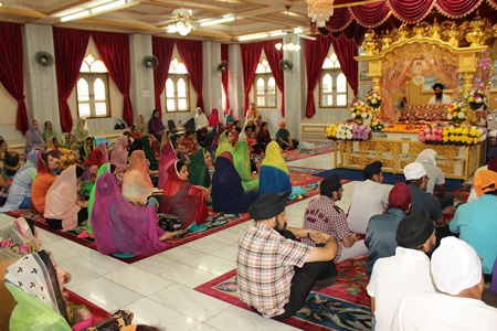 The Sikh congregation prays to the Guru Granth Sahib, the Sikh Holy Scripture.