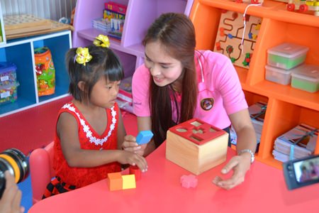 A beautiful young child learns shapes from a dedicated teacher at the center.