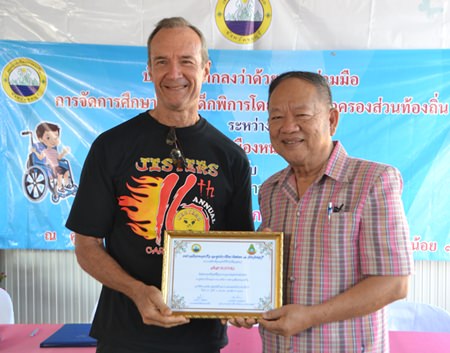 Nongprue Mayor Mai Chaiyanit presents a certificate of appreciation to Jesters Care for Kids President Lewis 'Woody' Underwood.