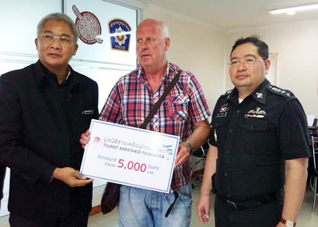 Suphisarn Pakdeerunart (left) presents the emergency donation to Swedish tourist Tor Langseth.
