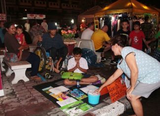 10-year-old market vendor becomes social-media sensation Eakmongkol “Nong Miw” Samerpark, with his family in the background, sells a drawing and receives a donation at the Thepprasit second-hand market.