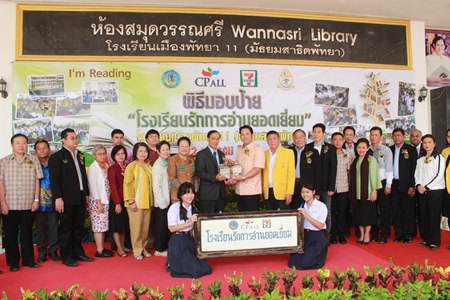 Suwit Kingkaew (center left), senior vice president of CP All Plc., presents Pattaya’s first “Love to Read School” sign to Mayor Itthiphol Kunplome (center right) and other officials representing Pattaya School No. 11.