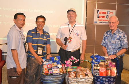 Pattaya Mail reporters Surasak Huasoon and Urasin Khantaraphan show the 3 gift baskets donated by Urasin to PCEC Chairman Roy Albiston and Vice Chairman Richard Smith, which will be raffled off by the PCEC for funds to donate to charity.