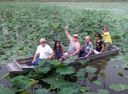 Tour members being paddled among the Lotus plants when they visited the Lotus farm in Nakhon Pathom Province.