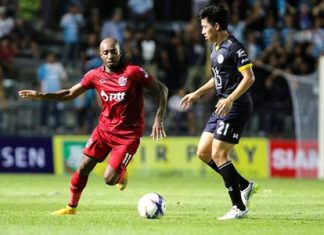 Pattaya United midfielder Sivakorn Tiatrakul (right) attempts to shield the ball from PTT Rayong’s Yves Desmarets during the second half of their Thai Division 1 league match at the Nongprue Stadium in Pattaya, Saturday, Feb. 21. (Photo courtesy PTT Rayong FC)