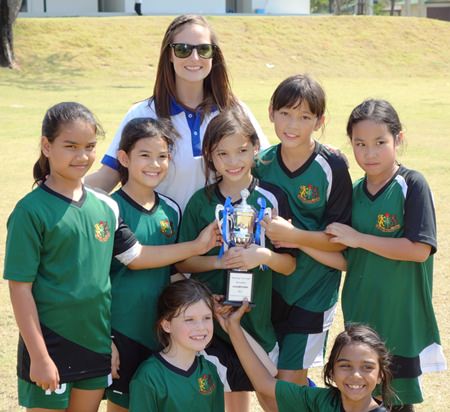 GIS’s under-9 girls football team with coach Ms Natalie.