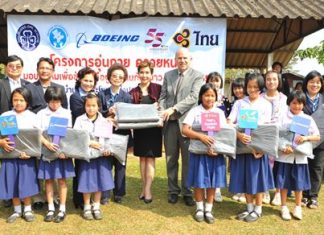 Petchpring Sarasin (back row, fifth from left), THAI Vice President of Corporate Image & Communications Department, with David Bizar (back row, sixth left), Field Service Regional Manager of the Boeing Company (Thailand), hand over 1,000 blankets that were donated to students in Wieng Pa-Pao district, Chiang Rai province, which were received by Chao Dararat Na Lampoon (back row, fourth left), alongside Prasert Jitpleecheep (back row, second left), Marshal of Wieng Pa-Pao district, Chiang Rai province.