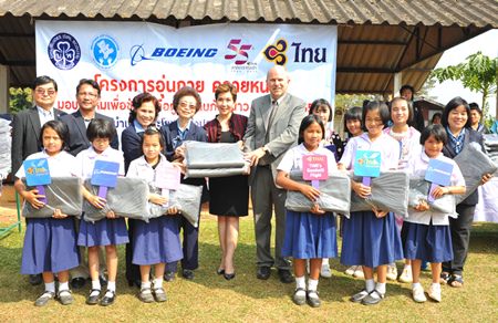 Petchpring Sarasin (back row, fifth from left), THAI Vice President of Corporate Image & Communications Department, with David Bizar (back row, sixth left), Field Service Regional Manager of the Boeing Company (Thailand), hand over 1,000 blankets that were donated to students in Wieng Pa-Pao district, Chiang Rai province, which were received by Chao Dararat Na Lampoon (back row, fourth left), alongside Prasert Jitpleecheep (back row, second left), Marshal of Wieng Pa-Pao district, Chiang Rai province.