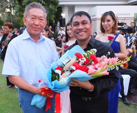 Dr. Pornthep Phornprapha President of Siam Motors Co (left) presents flowers to conductor Lt. Col. Prateep Suphanrojn.