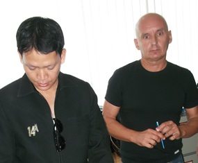 Hungarian fugitive captured in Pattaya after being granted long-term visa Lajos Czegledi (right) signs documents acknowledging he is being arrested.