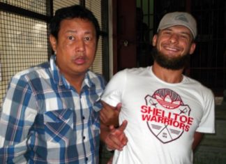 Sergey Kovalenko smiles for the camera as he is led into jail.