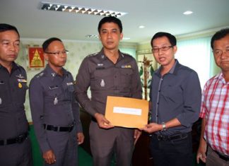 Kantapon Sukumalin hands his complaint over to Pattaya police superintendent Pol. Col. Sukthat Pumpunmuang.