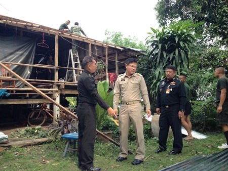 Officials inspect the damage as soldiers begin to repair a damaged roof on Koh Chan.
