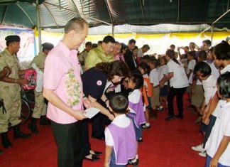 Gov. Khomsan Ekachai (foreground) leads government officials in handing out scholarships during the Chonburi outreach visit to the Khongdara Temple community in Sattahip.