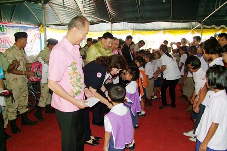 Gov. Khomsan Ekachai (foreground) leads government officials in handing out scholarships during the Chonburi outreach visit to the Khongdara Temple community in Sattahip.