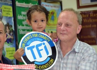 Derek Franklin from the Father Ray Foundation and Sean Madden from Murphy’s Law with a child from the center.