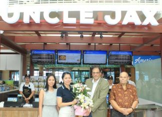 Thassarat Meekumsat (2nd left), tenant service manager of Central Festival Pattaya Beach, presents a basket of flowers to Marc Schreiber, CEO Indulge International LLC, as David Judge (right), managing director of Indulge Co, Ltd., (Thailand), and Kwanchanok Thaenthongthanakul (left), director of operations-Uncle Jax American Gourmet Popcorn, look on during the opening of the first Uncle Jax American Gourmet Popcorn in Southeast Asia.