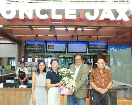 Thassarat Meekumsat (2nd left), tenant service manager of Central Festival Pattaya Beach, presents a basket of flowers to Marc Schreiber, CEO Indulge International LLC, as David Judge (right), managing director of Indulge Co, Ltd., (Thailand), and Kwanchanok Thaenthongthanakul (left), director of operations-Uncle Jax American Gourmet Popcorn, look on during the opening of the first Uncle Jax American Gourmet Popcorn in Southeast Asia.