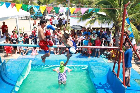 Youngsters battle in the traditional sea boxing competition - stay on the pole and you win, fall off and you lose.