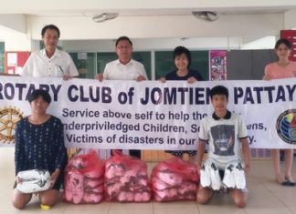 Rotary Club of Jomtien-Pattaya President Vutikorn Kamolchote (left) hands over the donated shoes to Pastor Praison of the RPB Church in Laem Chabang.