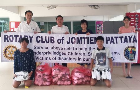 Rotary Club of Jomtien-Pattaya President Vutikorn Kamolchote (left) hands over the donated shoes to Pastor Praison of the RPB Church in Laem Chabang.