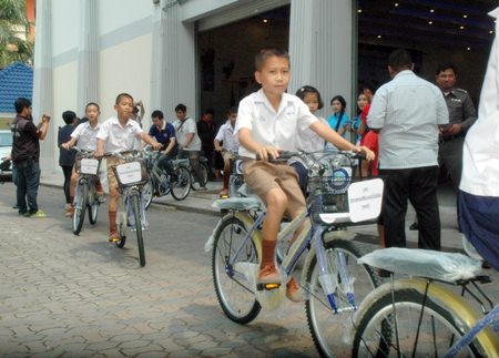 Little Mr. Nut leads outstanding students with poor family backgrounds as they test out their new bikes.