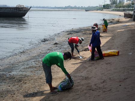 City workers clean the dark stains that marred the Naklua Beach, with most saying it looked like oil. However, a Marine Department spokesperson said it was natural sediment washed in by waves, not oil.
