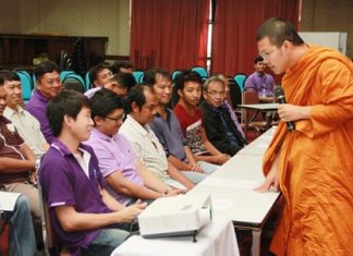 Pra Ajarn Mahachanchai (right) talks to city workers about ethics and moral development.
