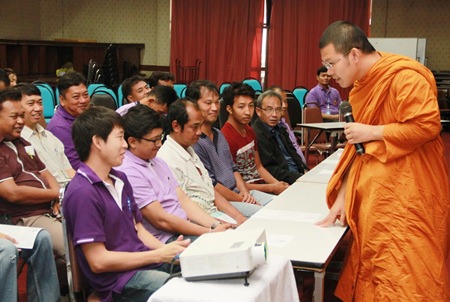 Pra Ajarn Mahachanchai (right) talks to city workers about ethics and moral development.