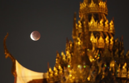 A total lunar eclipse was observable throughout Thailand shortly after moonrise last Saturday, April 4.  Shown here rising behind the Plubplachai temple in Bangkok, the eclipse was also viewable on a clear night here in Pattaya. Unusually short, the event was the first and only full lunar eclipse observable from Thailand this year. In total, it lasted for or 3 hours and 31 minutes, although the moon was shadowed entirely by the earth’s umbra for only 5 minutes. (AP Photo/Sakchai Lalit)