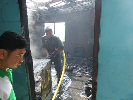 Fire police extinguish the final embers after the conflagration destroyed the house of a 104.75 radio technician on Pratamnak Hill.
