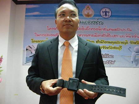 Chief Justice Apichart Thepnoo presents one of the GPS tracking bracelets.