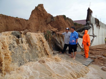 Nongprue Mayor Mai Chaiyanit and his officials inspect the wall built to keep this from happening, but which was no match for Mother Nature.